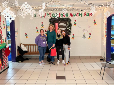 (From left to right) Mrs. Trevino, Mrs. Christiansen, and two Tallwood students in the back of the C-hall, which won best holiday door