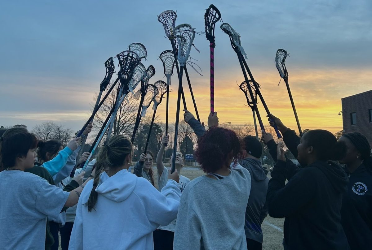 Girls Lacrosse players join sticks.