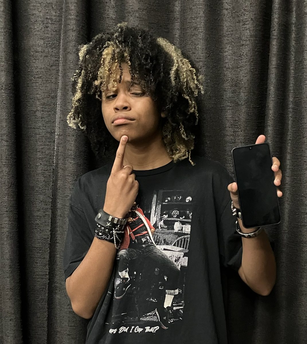 Jamie eyeing a phone inquisitively.